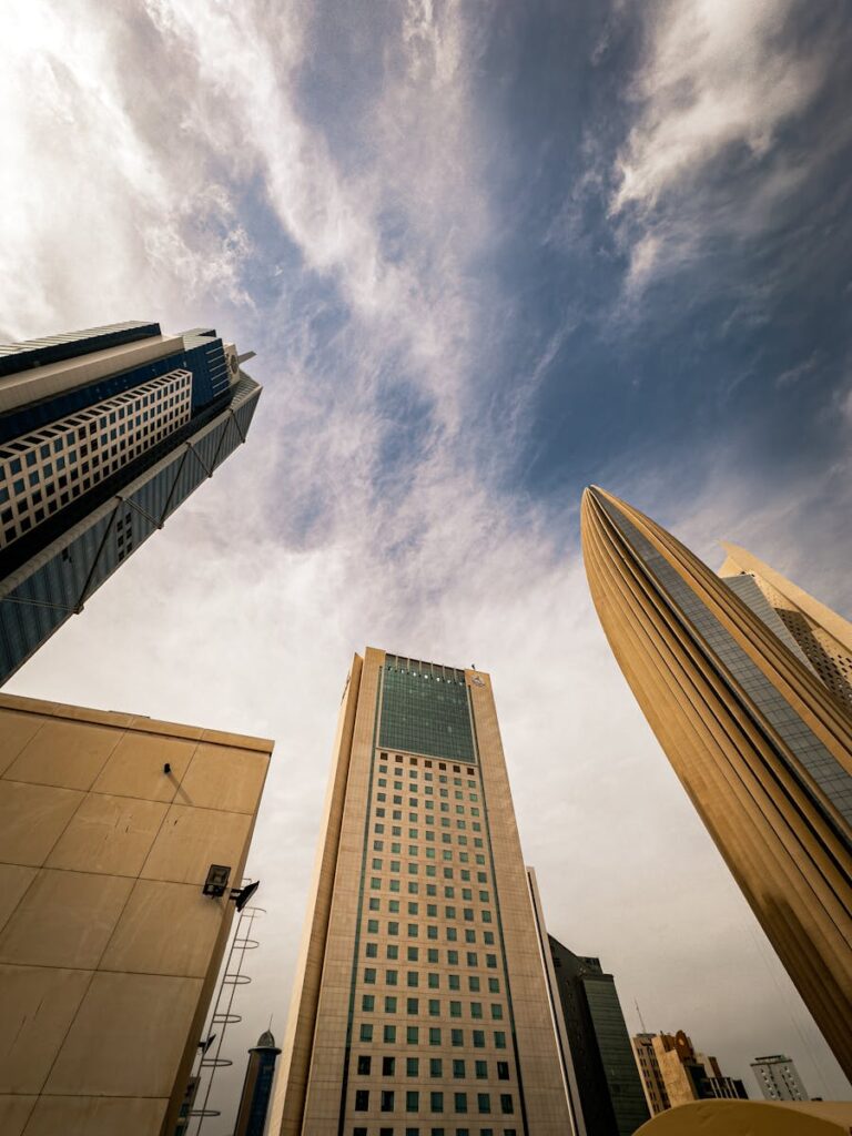 A stunning view of Kuwait City's modern architecture with prominent skyscrapers set against a dramatic sky.